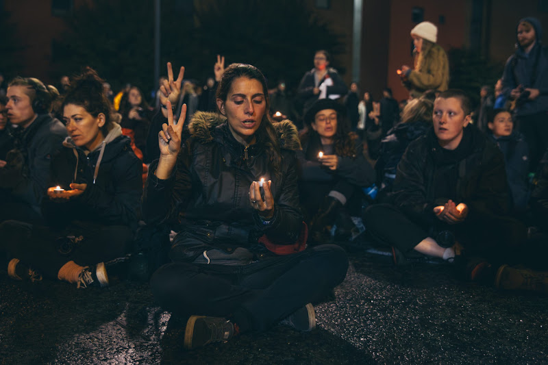 Activists Hold Up Peace Signs & Candles At Fish Market Protest
