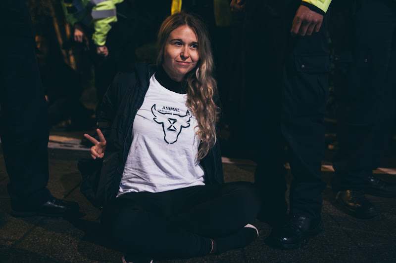 Arrested Activist Holds Up Peace Sign At Fish Market Protest
