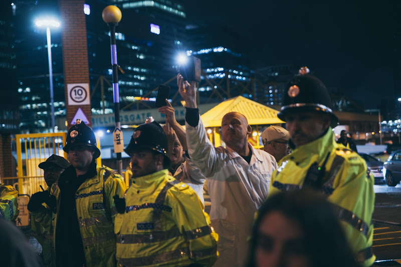 Fish Market Worker Takes Photos Of Activists From Behind The Police At Fish Market Protest
